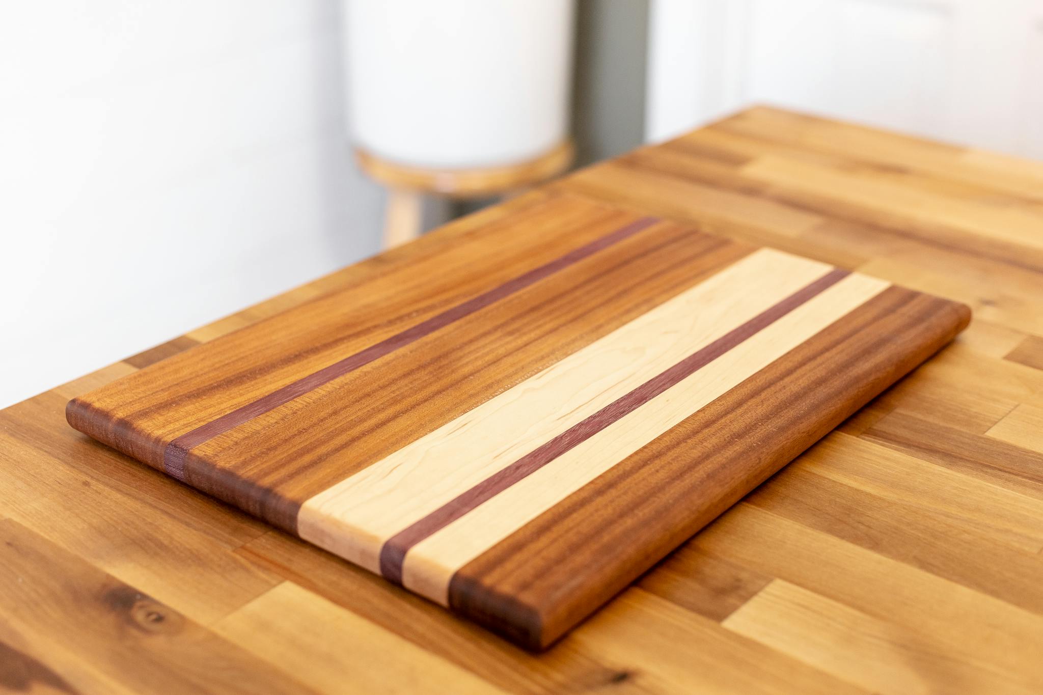 High-quality wooden cutting board with a striped pattern on a wooden table.